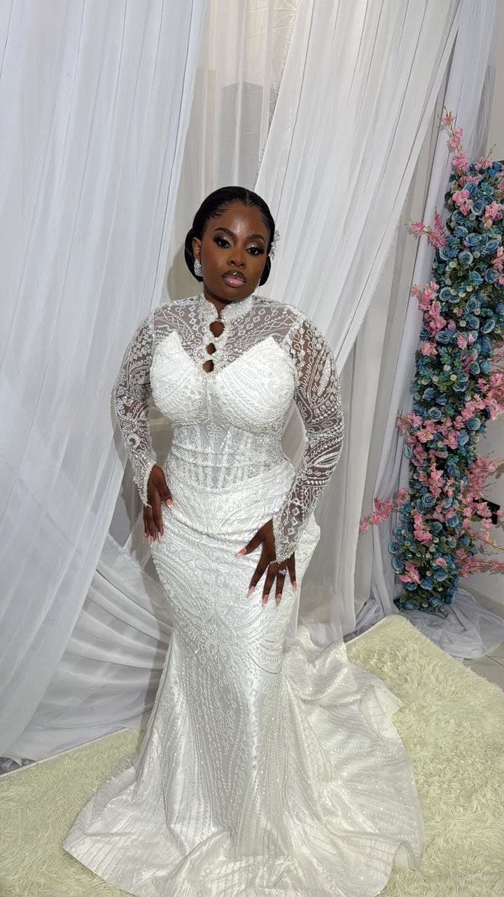 Bride smiling in a sheer veiled robe, curtain backdrop