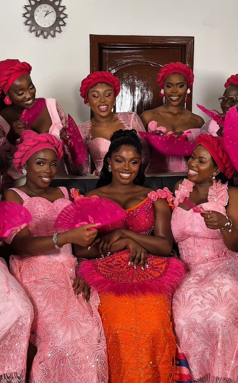 Bride with bridesmaids in pink robes, candid getting-ready moment
