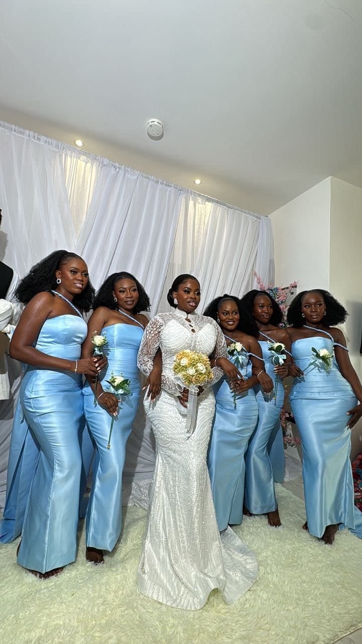 Bride and bridesmaids in light blue gowns holding bouquets