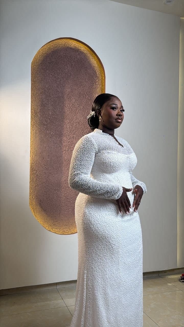 Bride in a white lace mermaid gown with a floral backdrop